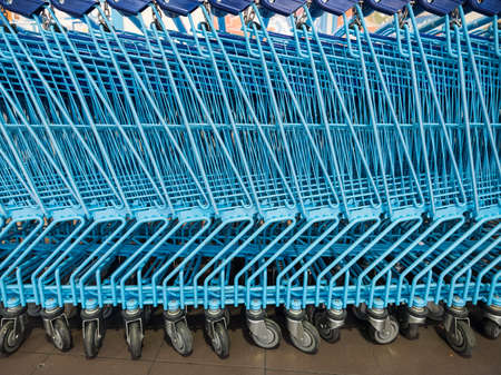 blue shopping carts wait outside supermarket for customers