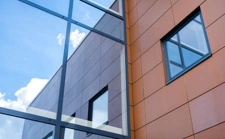 part of modern trade building with reflection in window and blue sky
