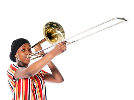 black teen girl with headscarf and musical instrument trombone against white backgroundの写真素材
