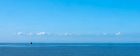 lonely old wooden sailing vessel on waddenzee north of the netherlands under blue sky in summerの写真素材