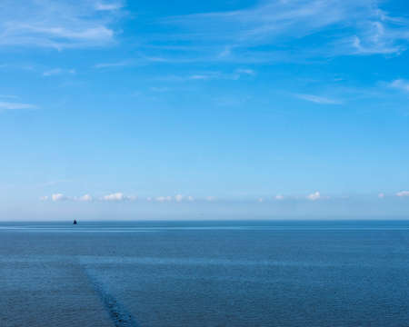 lonely old wooden sailing vessel on waddenzee north of the netherlands under blue sky in summerの写真素材