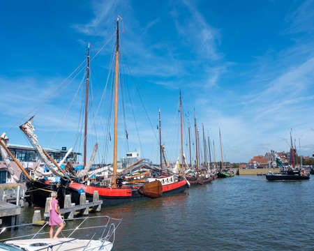 harlingen, netherlands, 23 august 2019: girl on motor yaught enters harbor of harlingen in frieslandのeditorial素材