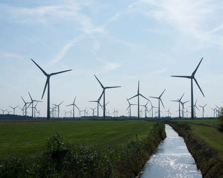 wind turbines in agriculture landscape of ostfriesland in the north of ostfriesland in lower saxony and blue skyの写真素材
