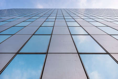 glass facades of modern office buildings and reflection of blue sky and clouds
