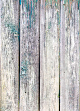 old grunge planks of door to woodshed with remains of old colored paintの写真素材