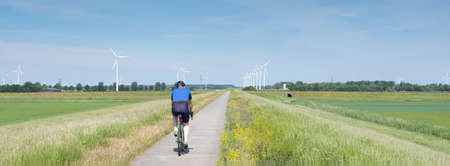 bicycle and spring flowers near area with wind turbines in dutch province of flevolandの写真素材