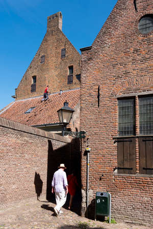 man in red shirt repairs medieval building in old centre of zutphen in the netherlandsのeditorial素材
