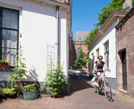 woman on bicycle in streets of old zutphen in the netherlandsのeditorial素材