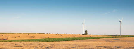fields after harvest in the north of france with wind turbines in the backgroundの写真素材