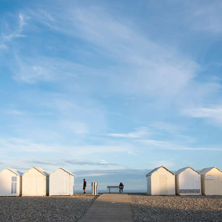 people near beach huts in cayeux s mer in french normandy under blue skyの写真素材