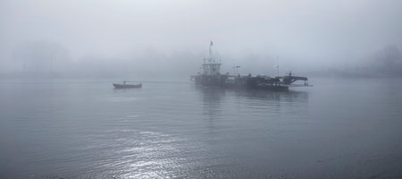 ferry in the mist on river lek near culemborg and utrecht in the netherlands