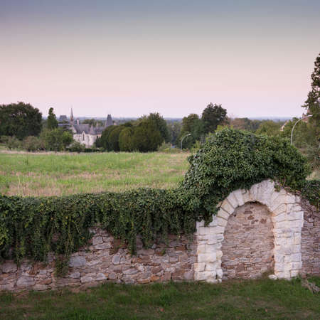 typical old stone walls and distant castle near river loire in franceの写真素材