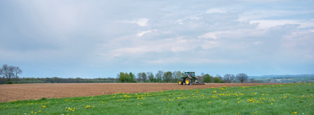 tractor and edge on plowed field in dutch province of south limburgの写真素材