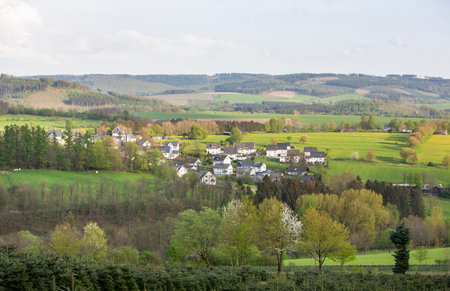 white houses in village near schmallenberg in spring and surrounding countryside of Sauerland in Germanyの写真素材