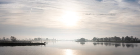 silhouettes of men fishing in river lek at sunrise on early morning in the fall