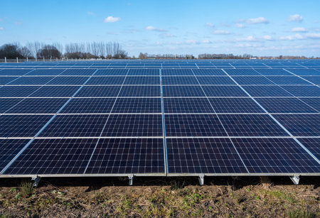 solar panel field under blue sky with fluffy clouds in dutch area near utrecht in the netherlandsの写真素材
