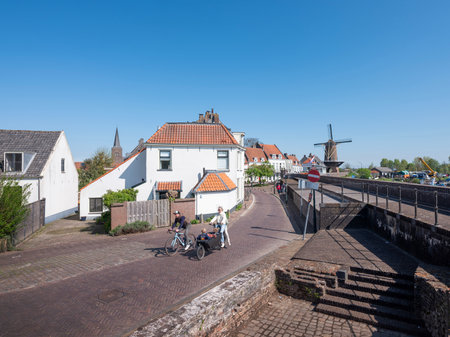 wijk bij duurstede, netherlands, april 20, 2025: family on bicycle and cargo bike in dutch town of wijk bij duurstede in holland under blue sky in springの写真素材