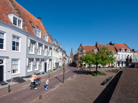 wijk bij duurstede, netherlands, april 20, 2025: mother and children run and ride bike in dutch town of wijk bij duurstede in holland under blue sky in springの写真素材