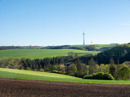agricultural countryside landscape in luxembourg with wind turbine under blue sky in springの写真素材