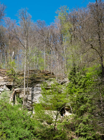 muellertal, luxembourg, april 29, 2025: people scramble on the rocks in muellertal on sunny day in springの写真素材
