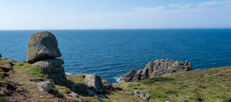 the southernmost point of cornwall shows cliffs hills and ocean near porthgwarra beach under blue...