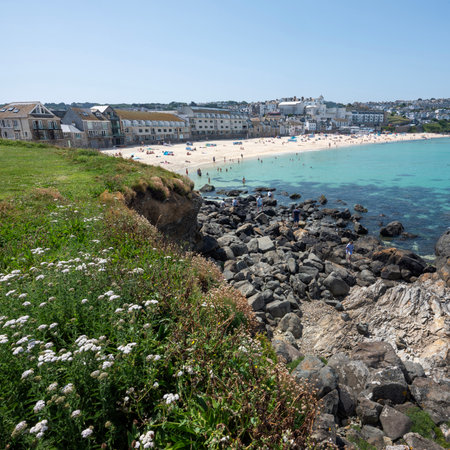 beach in st ives under blue spring sky in june full of people enjoying cornwall in england