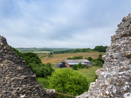 broken walls of Corfe Castle with farm and fields of south dorset in the backgroundの写真素材
