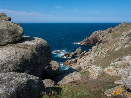 the southernmost point of cornwall shows cliffs hills and ocean near porthgwarra beach under blue...