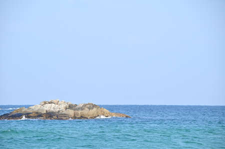 A small rock island floating on the blue seaの写真素材