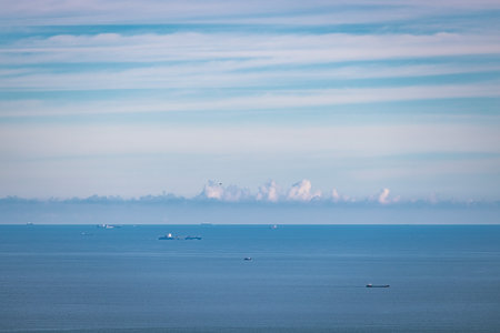 Cargo container ship on ocean horizon far away, daytimeのeditorial素材