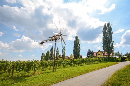 A road with a pinwheel Klapotetz through the vineyard, Southern Styria Austriaの写真素材