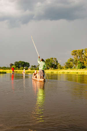 Canoe trip with traditional mokoro boat on the river through Okavango Delta near Maun, Botswana Africaの写真素材