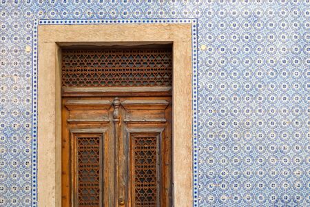 Exterior wall of a residential building with traditional portuguese tiles and entrance door in the Bairro Alto district in the old town of Lisbon, Portugalの写真素材