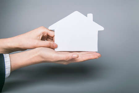 Creative concept - hand holding a paper houseの写真素材