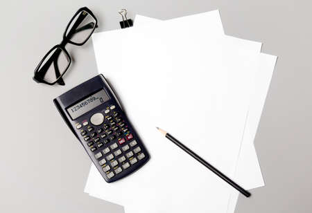 Desktop with papers, pencil, glasses and calculatorの写真素材