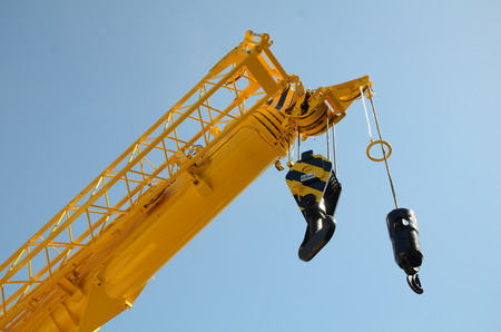 Yellow mobile crane against clear blue skyの写真素材