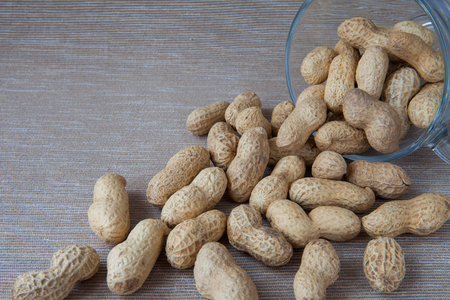 peanuts in the shell poured out of a cupの写真素材