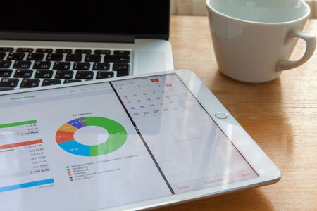 Moscow / Russia - March 2, 2013: White ipad lies on the macbook keyboard, on the diagram screen. Nearby is a cupのeditorial素材