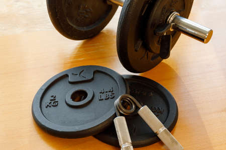 dumbbell and expander on a brown tableの写真素材