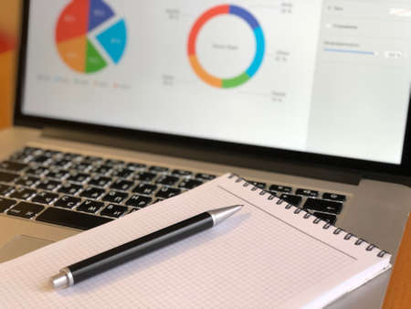 notebook with pen on laptop keyboardの写真素材