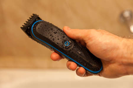 black electric razor in hand shower