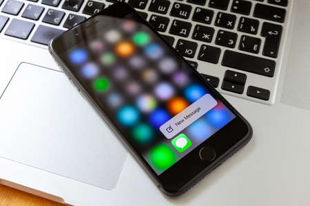 Moscow / Russia - May 14, 2019: Black iPhone on MacBook. on the iphone screen new messageのeditorial素材