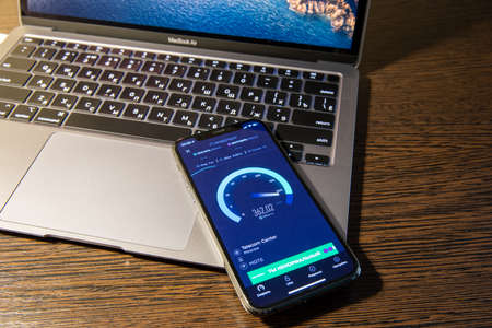 Moscow / Russia - March 8, 2021: iPhone 11 Pro lies on MacBook. Speedtest program on the iPhone...