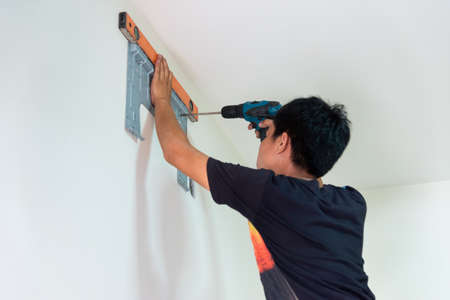 Man doing drilling holes on the wallの写真素材