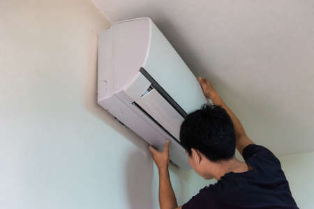 Technician you are checking air conditioning in white roomの写真素材