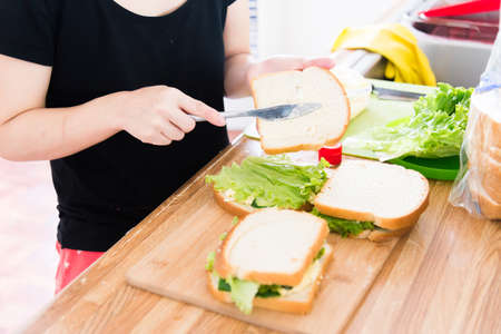 women making egg sandwich at kitchenの写真素材