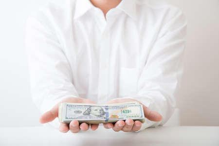 white shirt man holding cashの写真素材