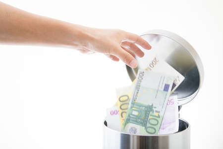 throwing away euro in waste can