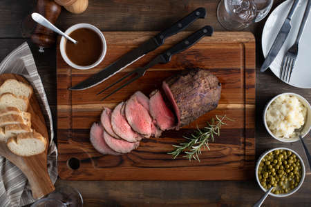 eye of round roasted beef with gravy sauce, potato and peas