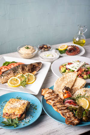 assorted popular greek plates on rustic wooden backgroundの写真素材